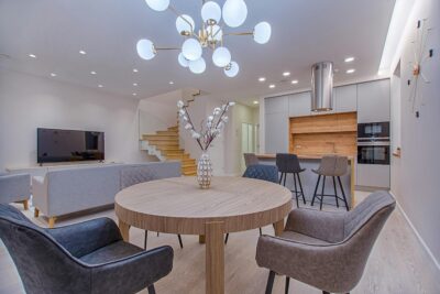 Stylish open-plan living room and kitchen with modern furnishings and lighting.