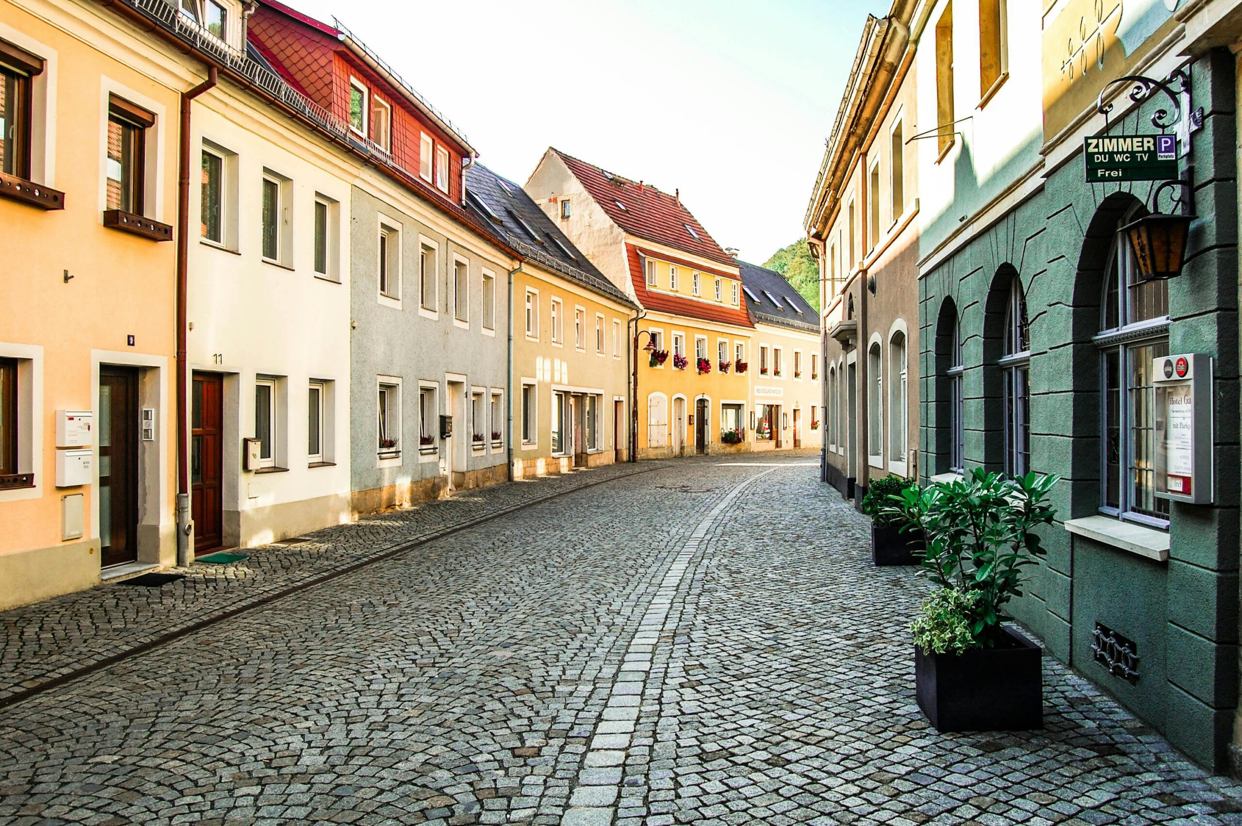 Explore a picturesque cobblestone street in Bad Schandau, Germany, showcasing colorful historic architecture.